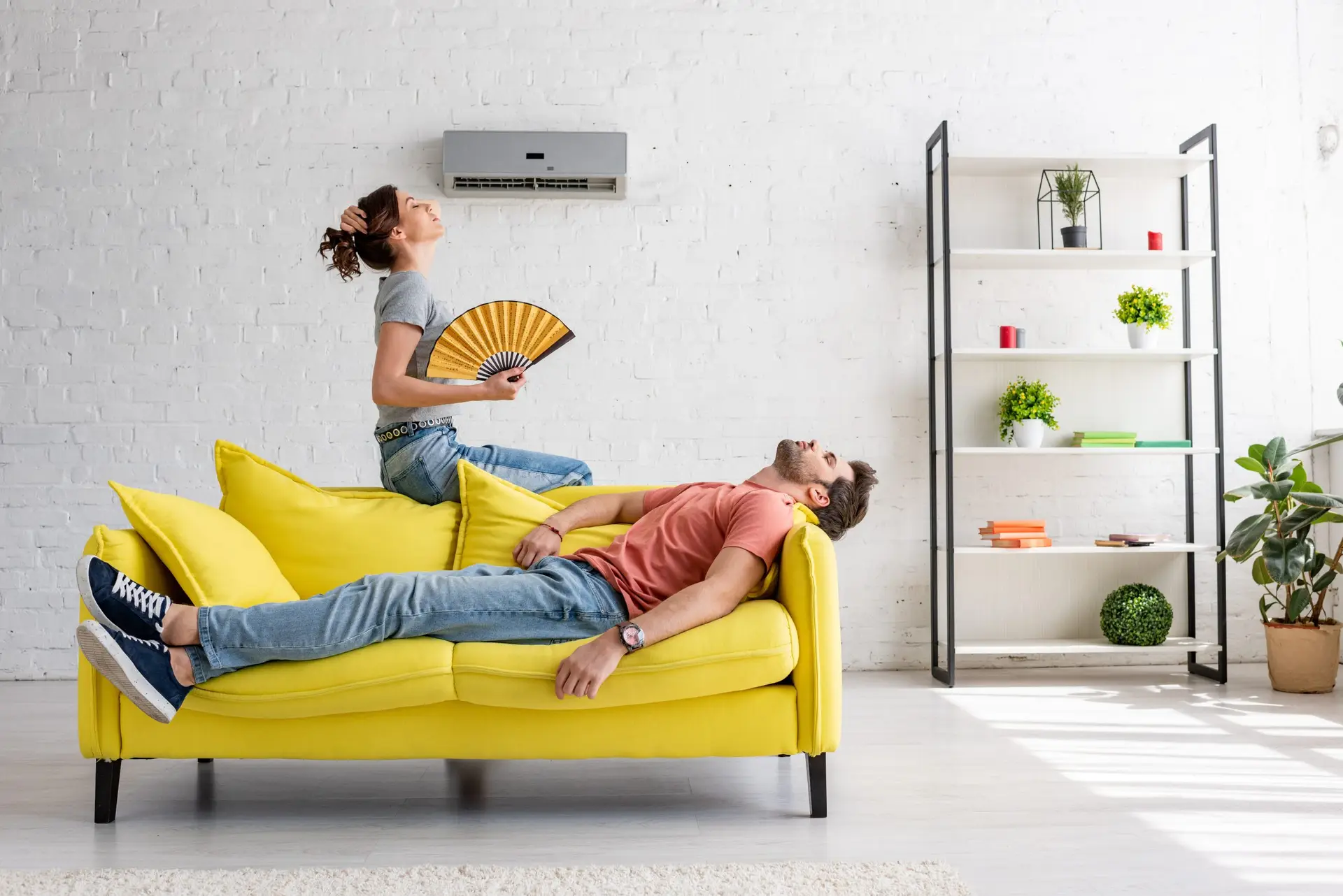 WCL London - exhausted man lying on yellow sofa under air conditioner